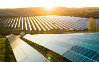 An image with an array of solar panels in a field on a sunny day
