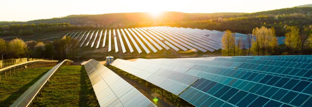 An image with an array of solar panels in a field on a sunny day