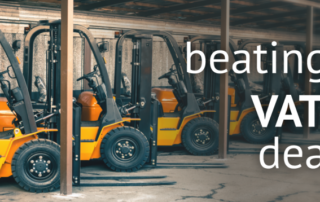 A digital banner displaying the words ' beating the VAT deadline' in large text, with forklift tracks in the background