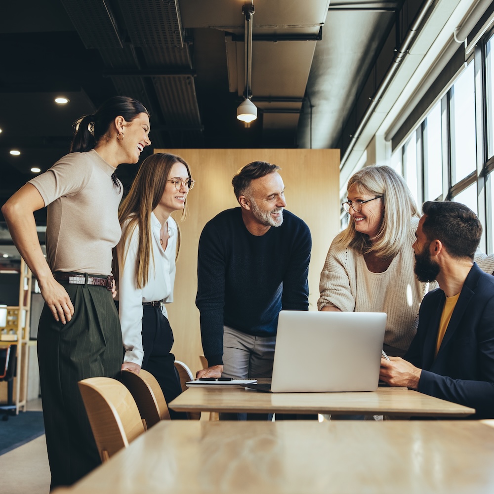 Smiling businesspeople having a discussion while collaborating on a new project in an office.