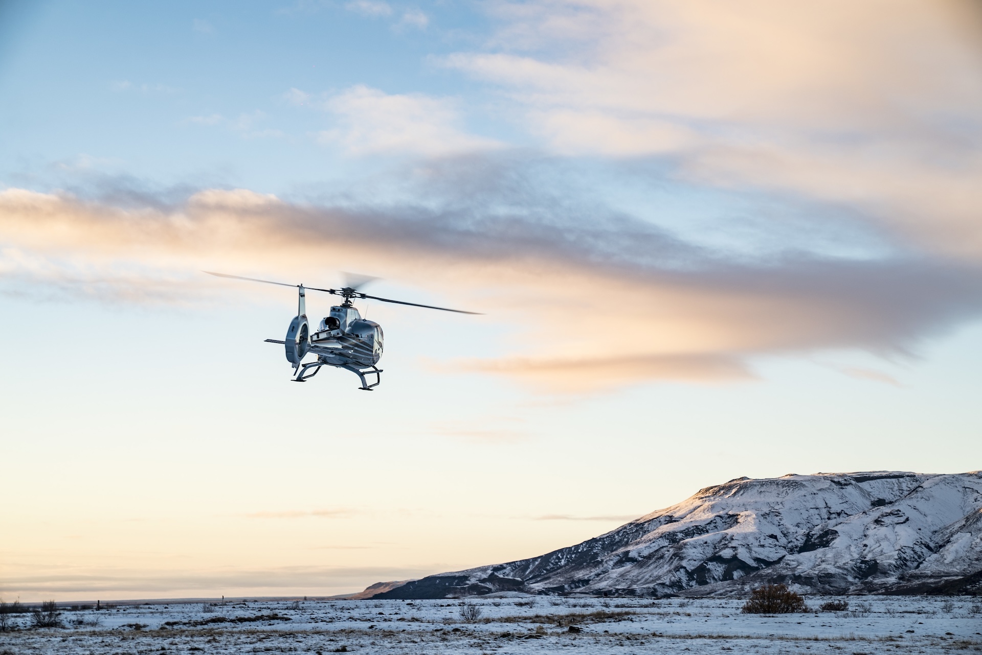 helicopter flies over snow covered tundra A image of a helicopter flying over snow covered tundra