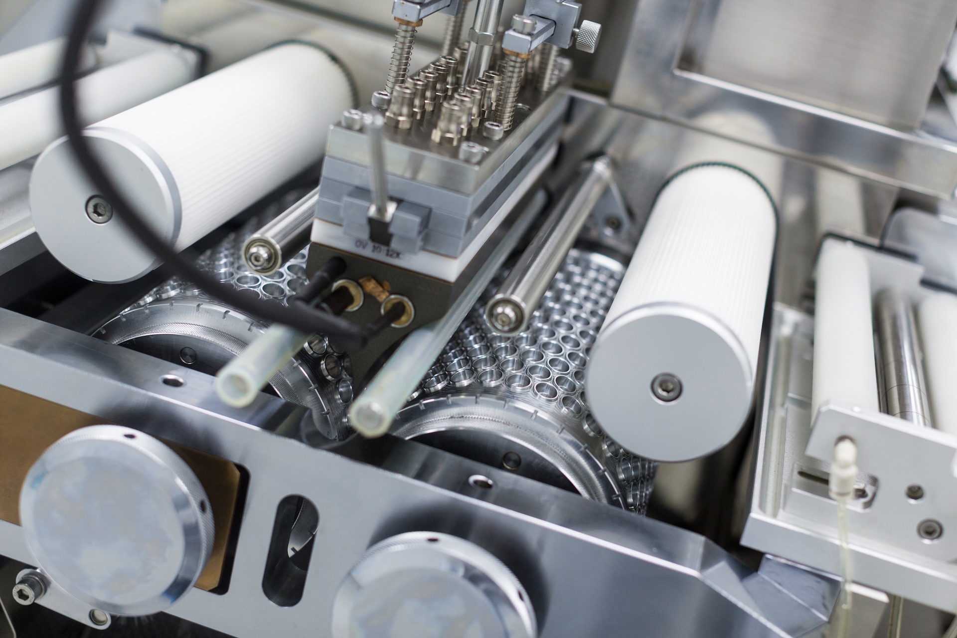 A close of a metal chromed manufacture machine with shafts, wires and electronics