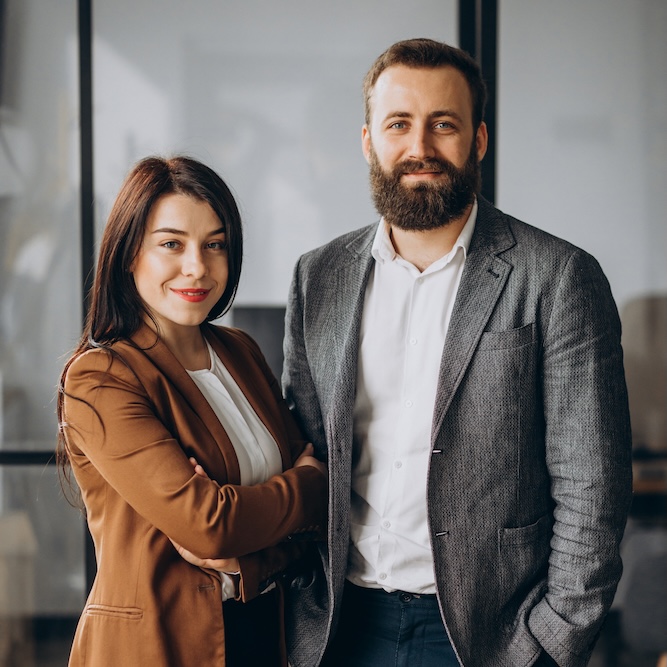 Two business workers posing together, smiling in an office setting