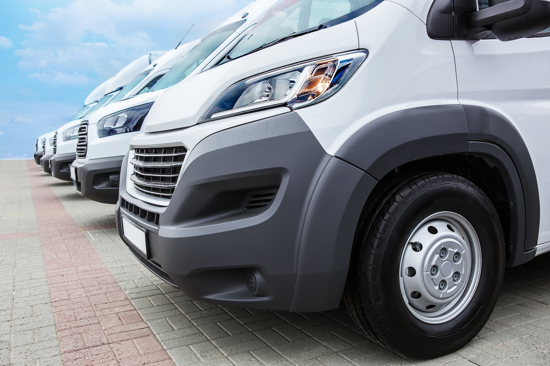 Number,Of,New,White,Minibuses,And,Vans,Outside A close up image of a row of white minibus vans